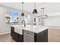 Modern kitchen island with stainless steel dishwasher and large single bowl sink at 25894 W White Feather Ln, Wittmann, AZ 85361