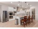 Modern kitchen features white cabinets, stainless appliances, kitchen island, and adjacent wine fridge at 31107 N 27Th Ave, Phoenix, AZ 85085