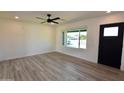Bright living room featuring sleek, light-colored flooring, fresh paint, and a ceiling fan at 3310 W Sweetwater Ave, Phoenix, AZ 85029