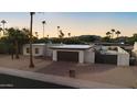 This single-story home features desert landscaping, mountain views, a gated pool and a brick driveway at 3615 E Charter Oak Rd, Phoenix, AZ 85032
