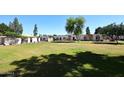 Expansive grassy area with mature trees and tidy single-story building exteriors on a sunny day at 5942 N 83Rd St, Scottsdale, AZ 85250