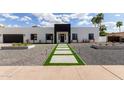 Daytime front exterior view featuring a sleek, modern design with concrete pathway and landscaped yard at 6539 E Sharon Dr, Scottsdale, AZ 85254