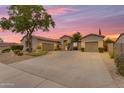 Beautiful single-story home boasts a circular driveway, desert landscaping, and a three-car garage at sunset at 6870 S Justin Way, Chandler, AZ 85249