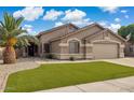 Charming single-story home with manicured lawn, desert landscaping, and attached two-car garage at 7457 W Crystal Rd, Glendale, AZ 85308