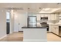Modern kitchen boasts stainless steel appliances, island and light colored cabinetry at 7970 E Camelback Rd # 110, Scottsdale, AZ 85251