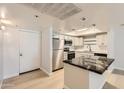 Kitchen with stainless steel appliances, light cabinetry and black marble countertops at 7970 E Camelback Rd # 110, Scottsdale, AZ 85251