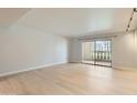 Bright living room featuring light wood floors and a sliding door with balcony access at 7970 E Camelback Rd # 110, Scottsdale, AZ 85251