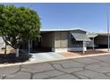 View of mobile home featuring covered parking, tidy landscaping and low maintenance yard for easy care at 8700 E University Dr # 1450, Mesa, AZ 85207