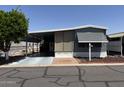 View of mobile home featuring covered parking, tidy landscaping and low maintenance yard for easy care at 8700 E University Dr # 1450, Mesa, AZ 85207