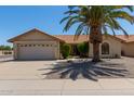 Charming single-story home featuring a terracotta roof, desert landscaping and a large palm tree in the front yard at 9123 W Utopia Rd, Peoria, AZ 85382