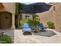 Relaxing patio featuring comfortable seating, an umbrella for shade, and charming landscaping at 9460 N 105Th Pl, Scottsdale, AZ 85258