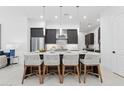 Kitchen island with seating, granite countertops, and modern pendant lighting at 1 Easy St # 15, Carefree, AZ 85377