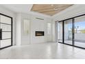 Bright living room with a fireplace, tile floors, wood ceiling feature, and sliding glass doors to a patio at 1 Easy St # 5, Carefree, AZ 85377
