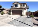 A suburban home featuring a two-car garage, neutral stucco, desert landscaping, and basketball hoop at 11121 E Sombra Ave, Mesa, AZ 85212
