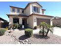 Inviting two-story home featuring a two-car garage, neutral stucco, desert landscaping, and shuttered windows at 11121 E Sombra Ave, Mesa, AZ 85212