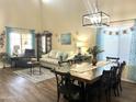 An airy living and dining space featuring vaulted ceilings, hardwood floors, and bright natural light at 11121 E Sombra Ave, Mesa, AZ 85212