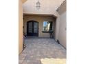 Elegant double front doors with decorative glass, set in a covered entryway with brick paving at 12937 W Calle De Sol --, Peoria, AZ 85383
