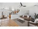 Open-concept living room with modern decor, light hardwood floors, and a ceiling fan at 1444 W Wickieup Ln, Phoenix, AZ 85027