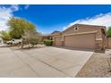 A well-maintained home featuring a three-car garage, xeriscaping, and clear driveway at 17773 W Manso St, Goodyear, AZ 85338