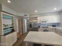 Open kitchen featuring white cabinets, stainless steel appliances, and a center island with stone countertop at 1904 E Jarvis Ave, Mesa, AZ 85204