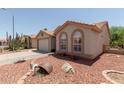 Charming single-story home with desert landscaping, barrel decor, and covered entryway at 1917 E Lindrick Dr, Chandler, AZ 85249