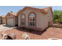 Charming single-story home with desert landscaping, barrel decor, and covered entryway at 1917 E Lindrick Dr, Chandler, AZ 85249