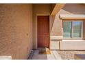 Home's entry showcases a welcoming front door, neutral siding, and an inviting aesthetic at 1956 N Hubbard Ln, Casa Grande, AZ 85122