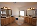 Primary bathroom with dual vanities, a soaking tub, and large mirrors, and neutral color palette at 19880 W Desert Views Dr, Casa Grande, AZ 85122