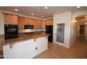 Updated kitchen featuring wood cabinets, granite countertops, stainless steel appliances and pantry door at 19880 W Desert Views Dr, Casa Grande, AZ 85122