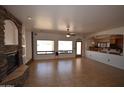 Spacious living room with stone fireplace, tile floors, and natural light from large windows at 19880 W Desert Views Dr, Casa Grande, AZ 85122