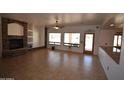 Spacious living room with stone fireplace, tile flooring and large picture windows bringing in natural light at 19880 W Desert Views Dr, Casa Grande, AZ 85122