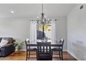 Dining room features a chandelier, seating for four, hardwood floors and natural lighting at 2119 E Daley Ln, Phoenix, AZ 85024