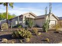 Inviting single-story home showcasing desert landscaping, including cacti and shrubs, providing a unique curb appeal at 2119 E Daley Ln, Phoenix, AZ 85024