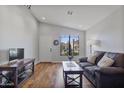 Bright living room with hardwood floors, a large window, and comfortable seating, creating a welcoming atmosphere at 2119 E Daley Ln, Phoenix, AZ 85024