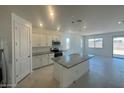 Bright open kitchen featuring an island with granite countertops and stainless steel appliances at 25138 W Wayland Dr, Buckeye, AZ 85326