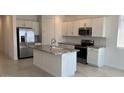 Bright kitchen features stainless appliances, granite counters, and a large island with a sink at 25138 W Wayland Dr, Buckeye, AZ 85326