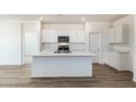 Modern kitchen features an island, sleek white cabinets, and stainless steel appliances at 25455 N 183Rd Dr, Wittmann, AZ 85361