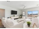Bright living room with modern furniture and stylish decor, featuring large windows with views of the landscape at 25876 W White Feather Ln, Wittmann, AZ 85361