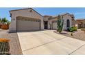 This beautiful home boasts a three-car garage and lovely desert landscaping at 25995 W Sierra Pinta Dr, Buckeye, AZ 85396