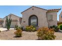 Desert-landscaped home with arched windows and a low-maintenance front yard at 25995 W Sierra Pinta Dr, Buckeye, AZ 85396