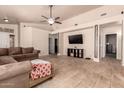 Bright living room with an open layout, complemented by tile flooring, a ceiling fan, and neutral decor at 2922 N 107Th Dr, Avondale, AZ 85392
