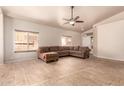 Spacious living room with large windows, tiled flooring, and a comfortable L-shaped sofa at 2922 N 107Th Dr, Avondale, AZ 85392