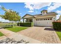 Inviting exterior showcasing a brick driveway, lush green lawn, and a charming facade under a bright blue sky at 3163 E Austin Dr, Gilbert, AZ 85296
