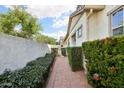 Cozy walkway lined with lush greenery and brick paving leading to the side entrance of the home at 3163 E Austin Dr, Gilbert, AZ 85296