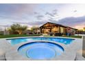 Luxury backyard featuring a sparkling pool and hot tub, outdoor kitchen, and play area at 35971 N Prickley Pear Rd, Cave Creek, AZ 85331