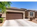 Single-story home featuring a two car garage and a low-maintenance xeriscaped front yard at 36454 W Picasso St, Maricopa, AZ 85138