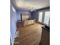 A bare bedroom featuring hardwood floors, a ceiling fan, light purple walls, and exterior access at 3914 E Andorra Dr, Phoenix, AZ 85032