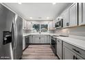 Updated kitchen features stainless steel appliances, grey cabinetry, and a bright window view at 5211 W Beryl Ave, Glendale, AZ 85302