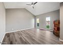 Open living room with vaulted ceilings, ceiling fan, and large windows providing plenty of light at 5211 W Beryl Ave, Glendale, AZ 85302
