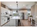 Bright kitchen featuring white cabinetry, stainless steel appliances, a center island, and wood-look tile flooring at 6850 E Mcdowell Rd # 29, Scottsdale, AZ 85257